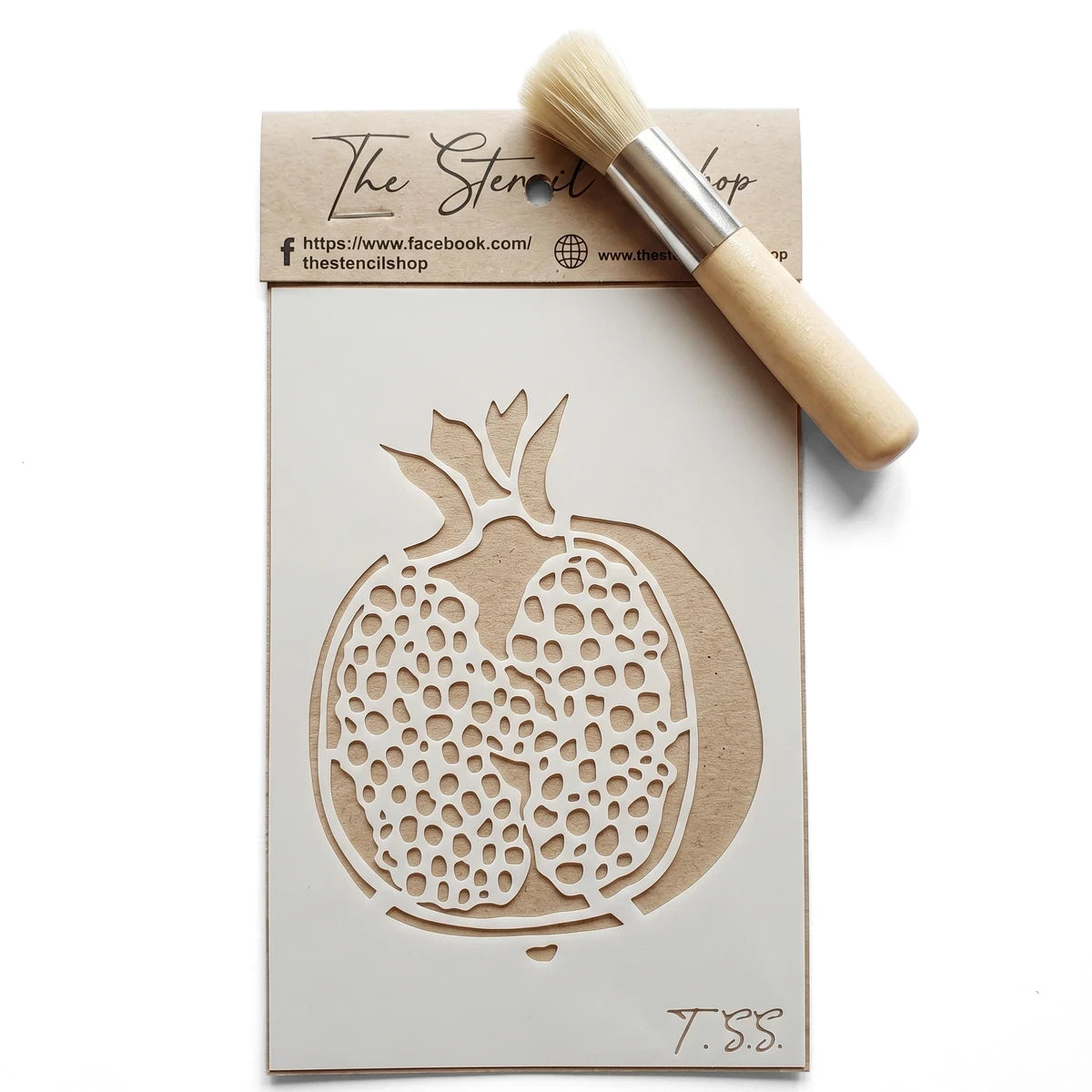 White 2022-A6-11 paint stencil featuring a detailed pomegranate design, displayed flat lay with a natural wood handle