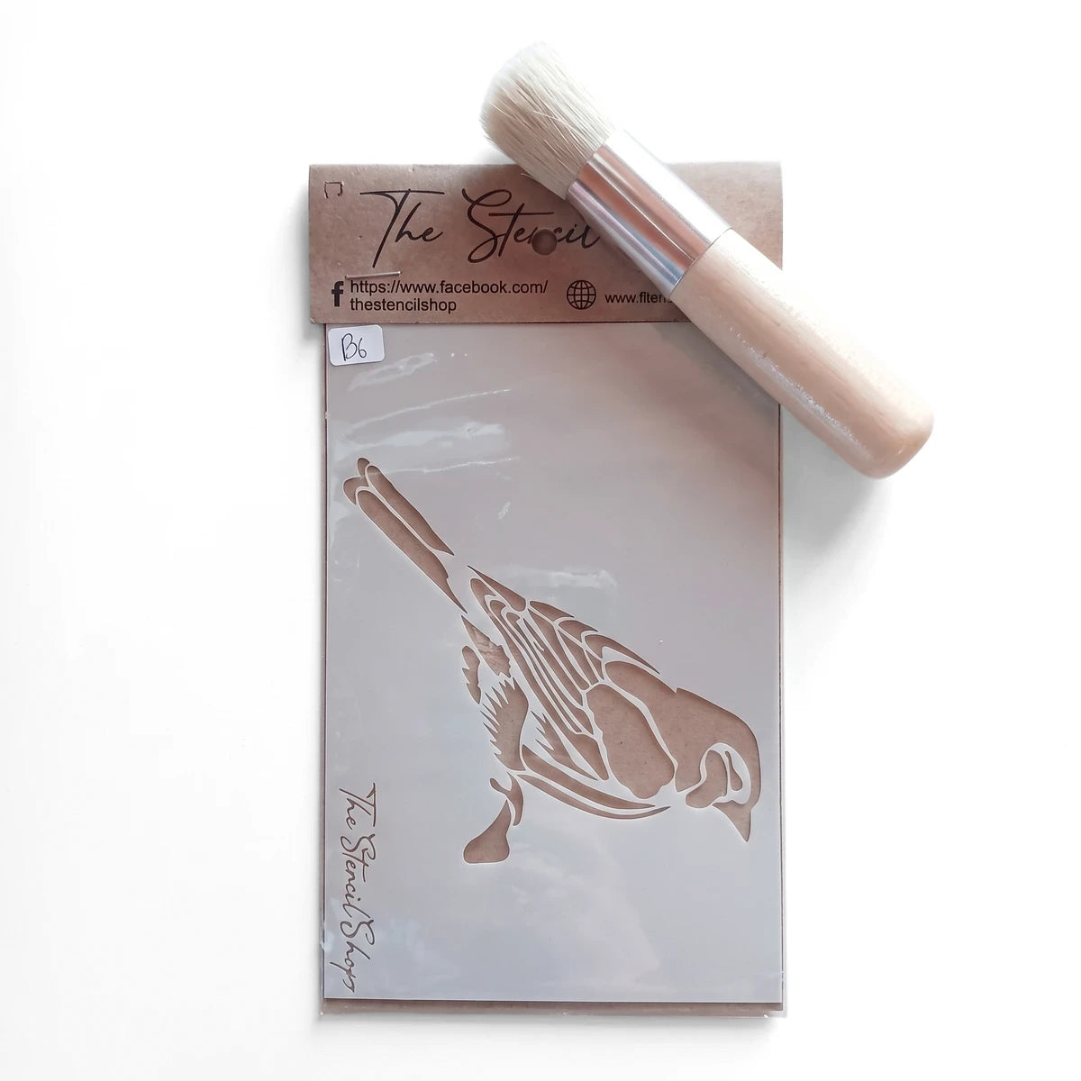 Bird design paint stencil with cardboard packaging and a light wood handle stencil brush, arranged diagonally.