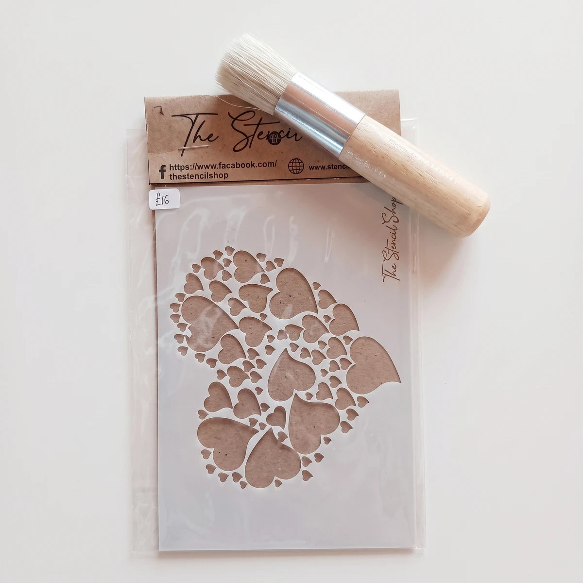 2022-A6-7 Paint Stencil with a heart pattern and a round bristle brush on a textured surface.