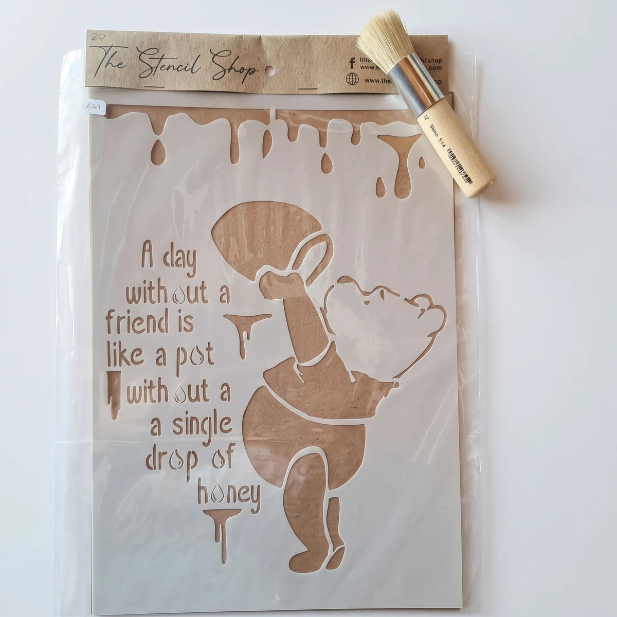 A4-20 Stencil 67 paint stencil featuring Winnie the Pooh with honey and a quote, accompanied by a small stencil brush.
