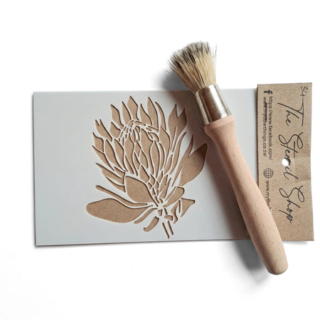 A6-34 stencil featuring a detailed protea flower design, displayed with a wooden stencil brush and a 'The Stencil Shop' tag.