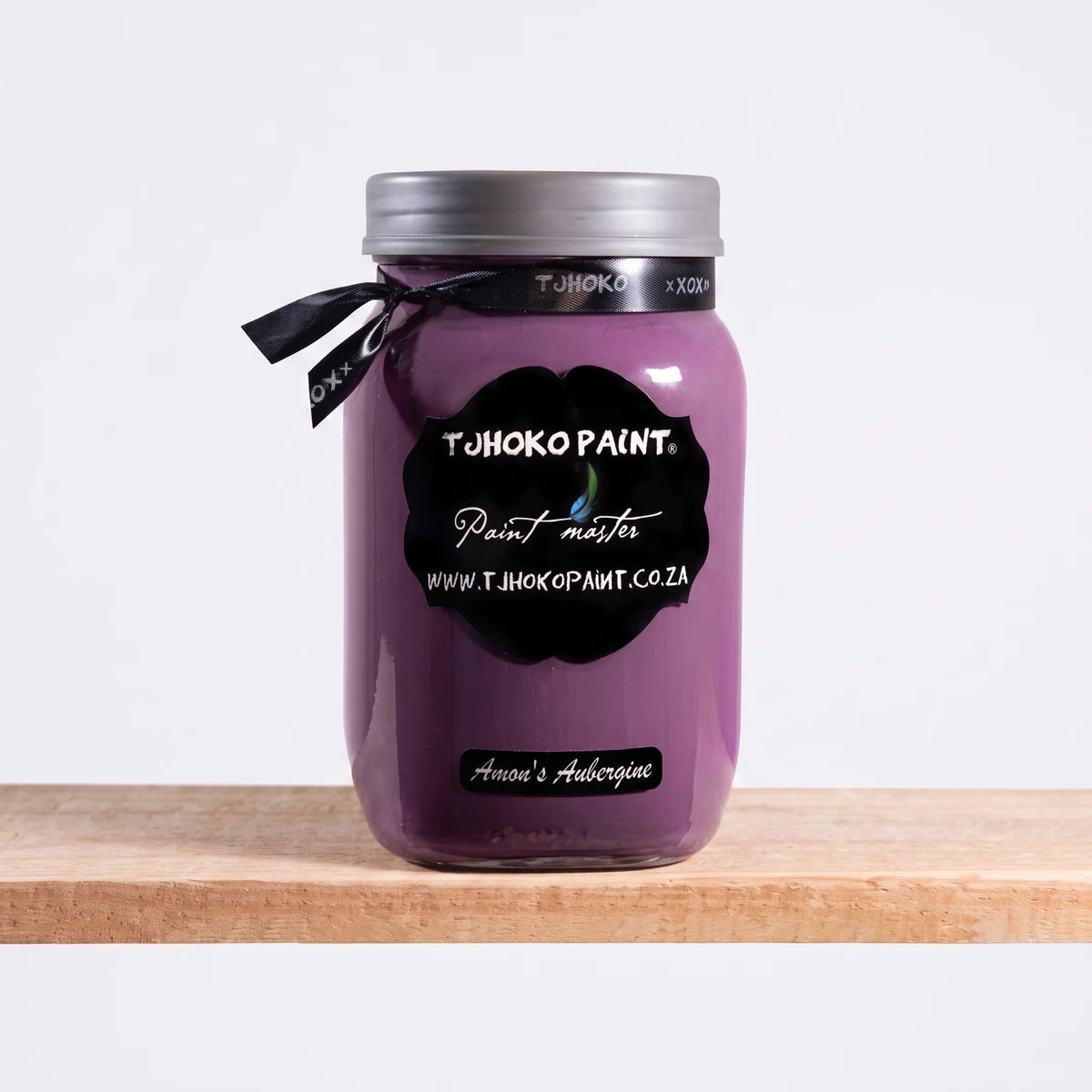 Amon's Aubergine 1L Chalk Paint in a glass jar with a silver lid, resting on a wooden shelf.