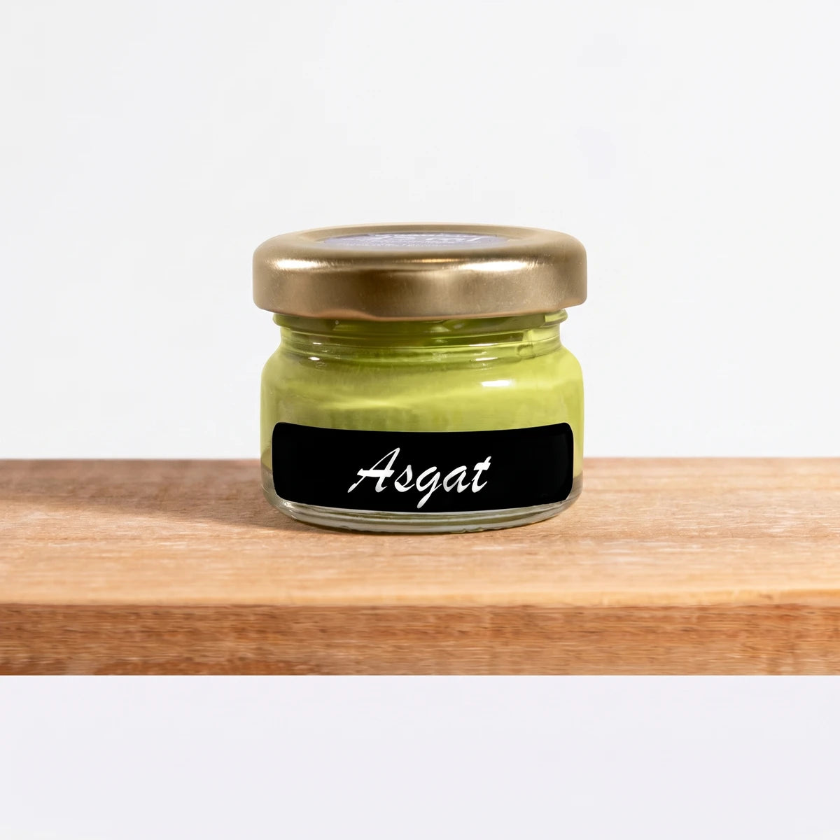 Asgat 25ml Chalk Paint in a clear glass jar with a gold lid, showcasing the light green color on a wooden shelf.