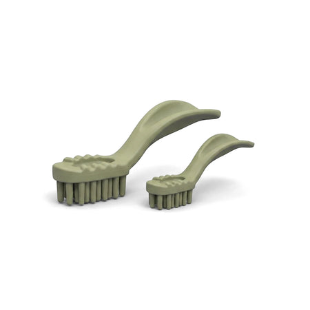 Two pale green brush-shaped dog dental chews from Bags O' Wags Denties Tooth Xs for pet oral hygiene.