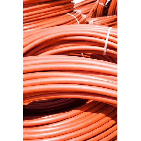 Coiled beige 6M x 22mm poly pipe bundles with white ties, stacked closely in a detailed view.