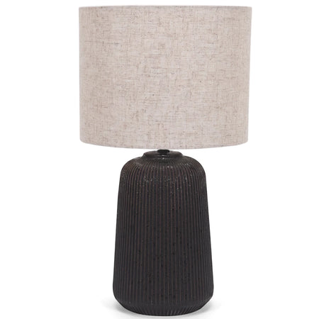 Black ceramic base table lamp with a textured vertical ridged base and a natural hessian fabric shade.