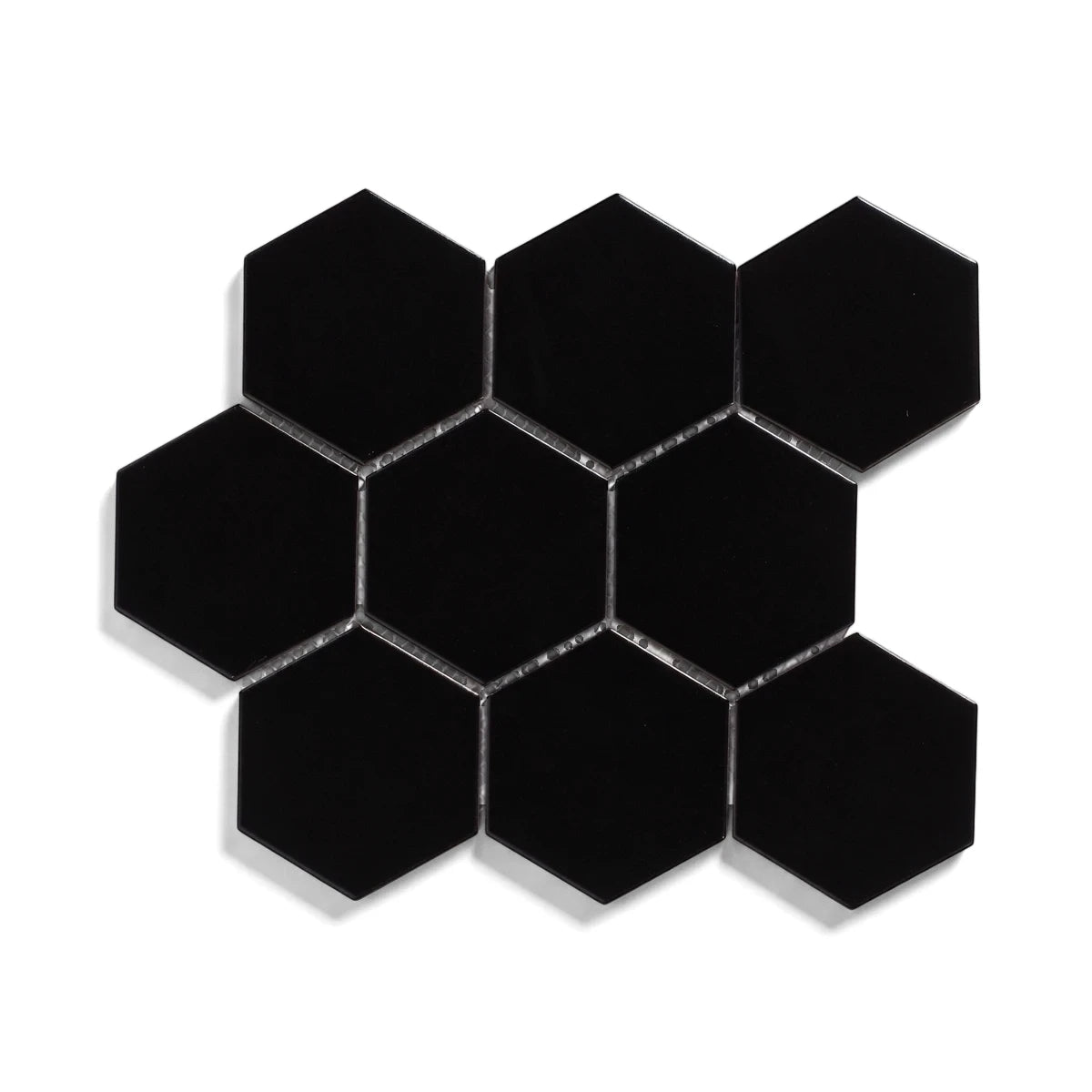 Black matte large hexagon mosaic tiles arranged in a geometric cluster with light gray grout, isolated on a clean white