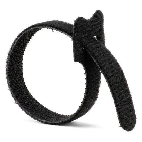 Black reusable cable tie in a curled loop, featuring a hook-and-loop texture for secure cable management.