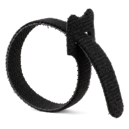 A single black reusable hook-and-loop cable tie curled in a loop on a white background, for cable management.