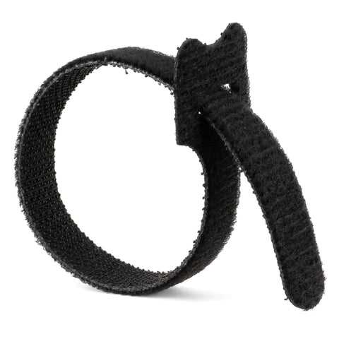 A single black reusable hook-and-loop cable tie curled in a loop on a white background, for cable management.
