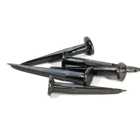 Five dark metallic blue tack nails, 16mm, piled together on a white background, used for construction.