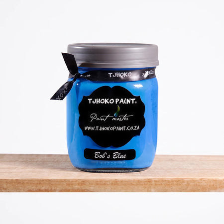 Bob's Blue 500ml Chalk Paint in a glass jar with a black label, silver lid, and black ribbon, displayed on a light wooden