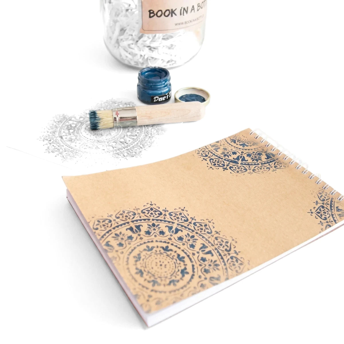 Book In A Bottle Arts & Crafts kit featuring an open notebook with blue mandala stamps, a paint jar, brush, and a glass jar