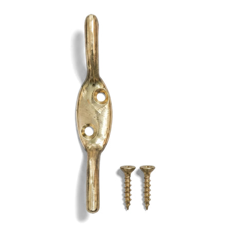 Polished brass cleat hook with two accompanying mounting screws, presented vertically on a clean white background.