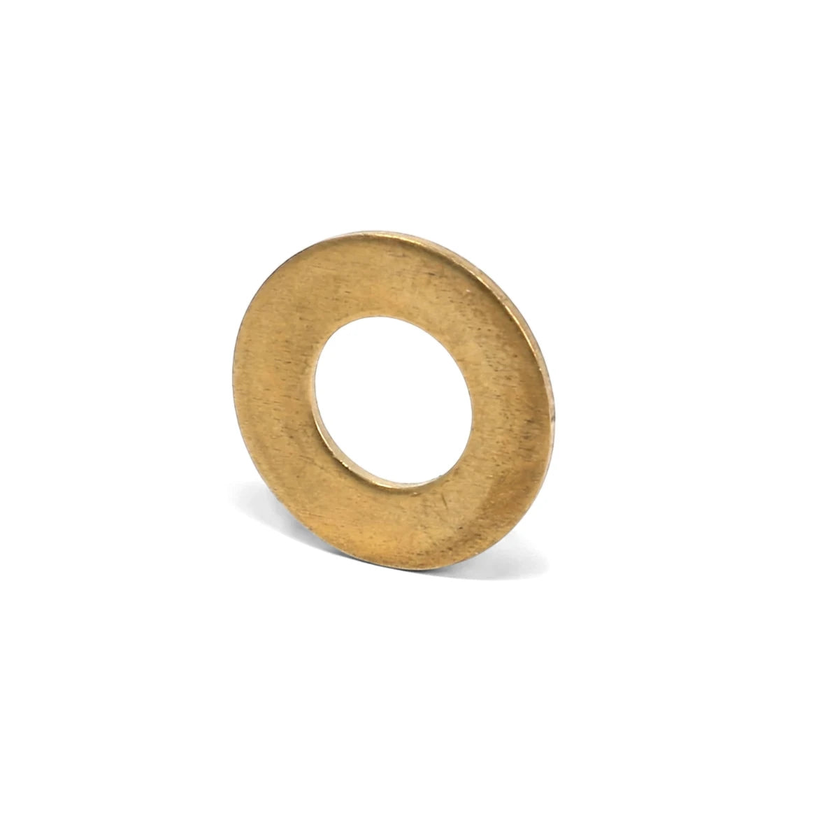 A single brass flat washer, circular and golden-toned with a brushed texture, shown at a slight angle on a clean white