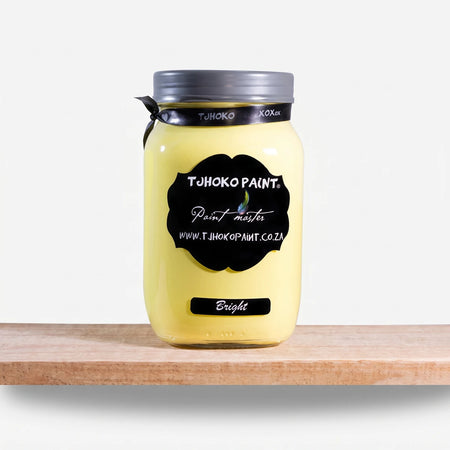 Bright 1L Tjhoko yellow chalk paint in a jar with a black label, resting on a rustic wooden shelf.