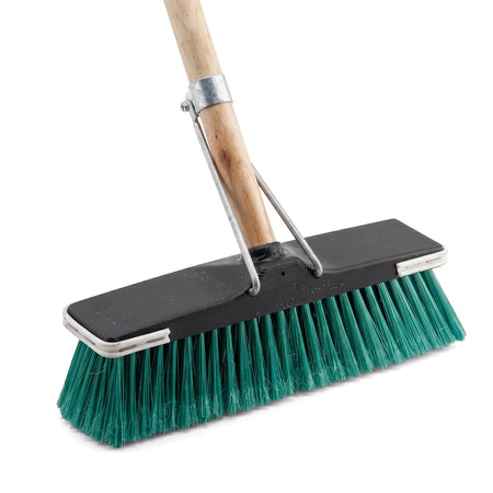 Angled view of a floor broom with a brown wooden handle, black head, and vibrant green bristles, designed for effective