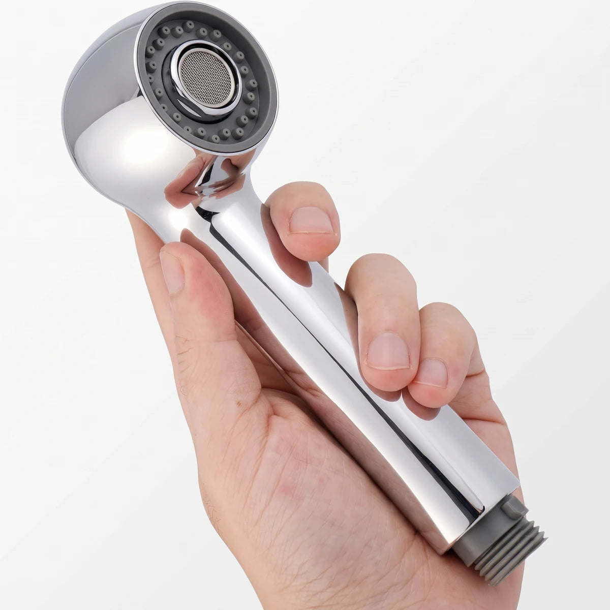 A chrome pull-out hose shower head with a gray spray face, held in a person's hand, against a white background.