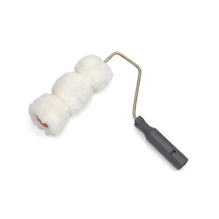 White fluffy complete corrugated roller, a paint application tool with a metal frame and dark grip, shown diagonally.