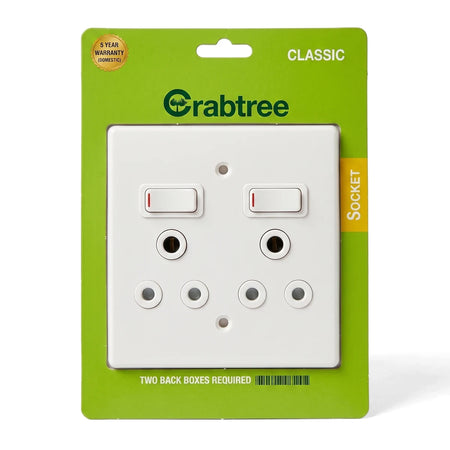 Crabtree Duo Sw Soc + Plate Assembled Switch Cover Plate in white, enclosed in its green and white retail packaging, front