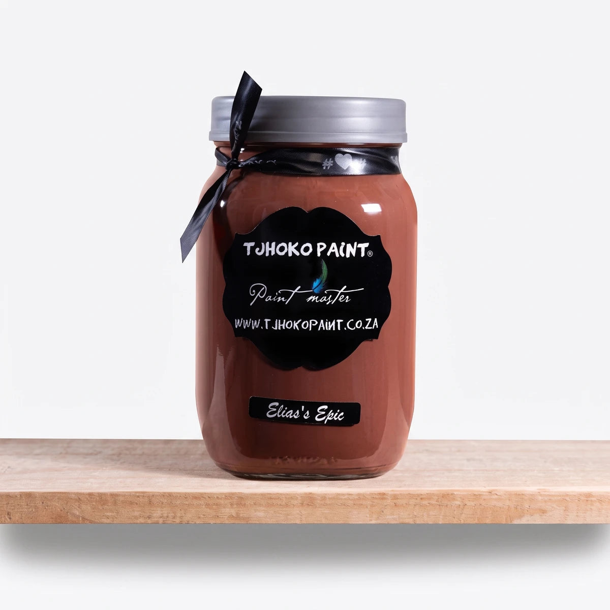 Elias' Epic 1Litre Tjhoko brown chalk paint in a clear glass jar with a gray lid and black ribbon, displayed on a wooden