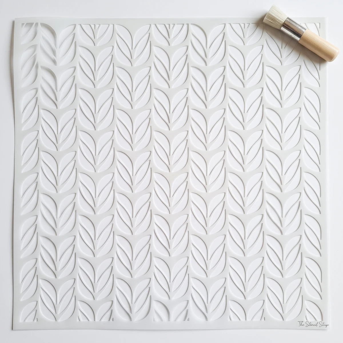 Eucalyptus Serenade paint stencil with a leaf pattern, square, white, shown with a small stencil brush.