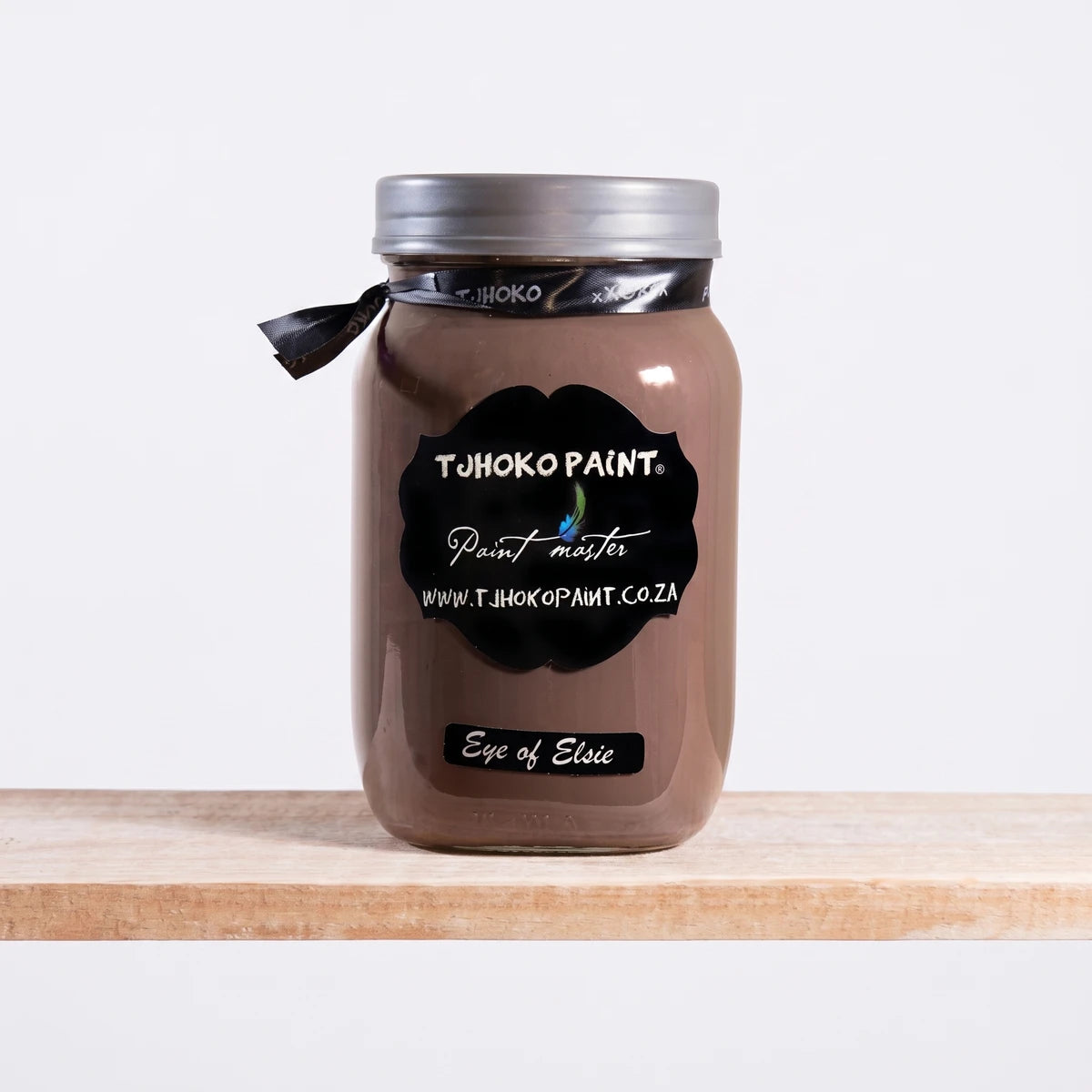 Eye Of Elsie 250ml Chalk Paint in a glass jar with a silver lid, brown-taupe color, displayed on a wooden shelf.