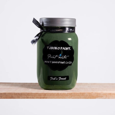 Frik's Forest 1L dark green chalk paint in a glass jar with a black label and ribbon, displayed on a wooden shelf.