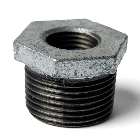Galvanized M&F reducing bushing, a threaded metal pipe fitting with a hexagonal top, shown in a close-up.