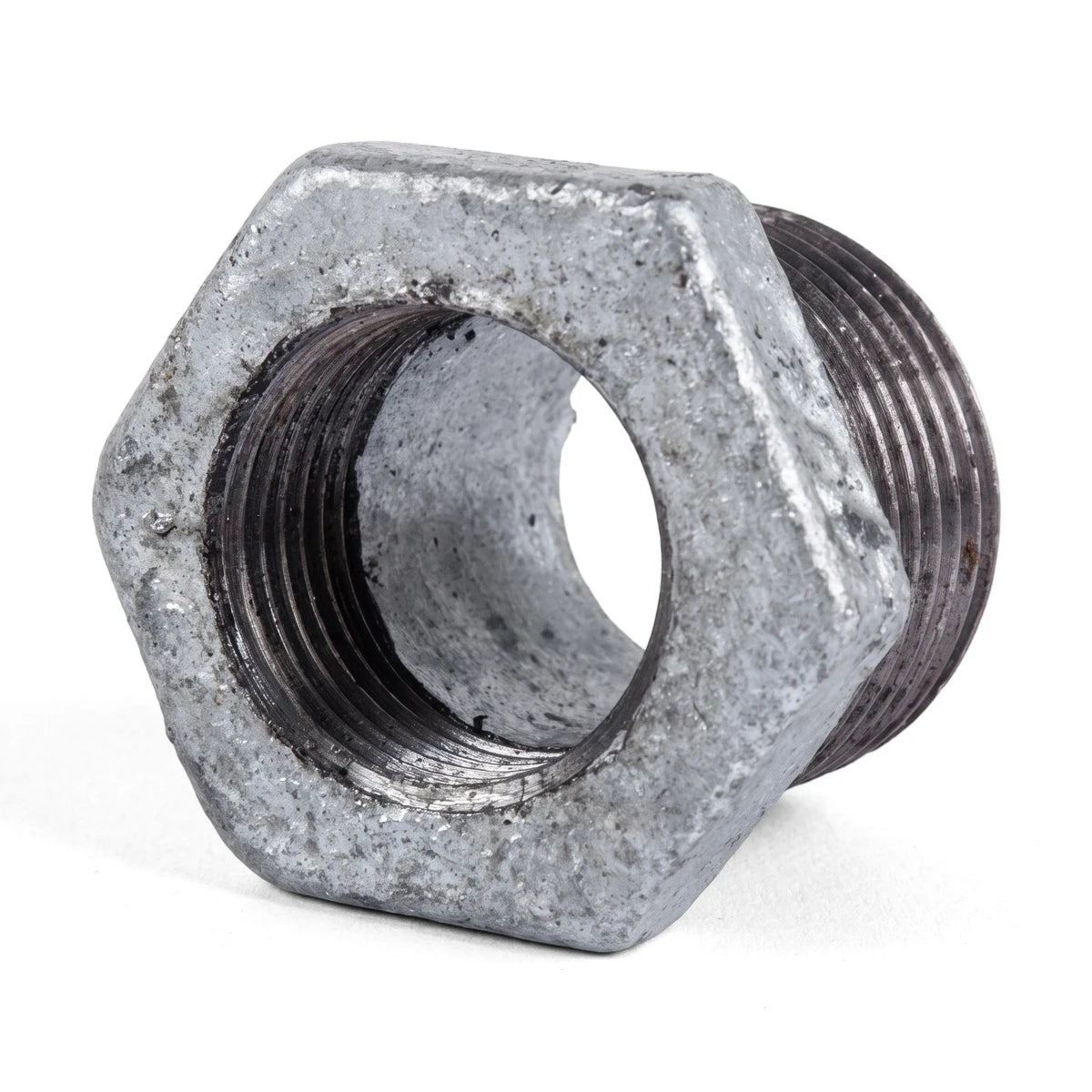 Close-up of a sturdy galvanized steel reducing bush, 50x32mm, featuring a hexagonal body and threaded interior, on a white