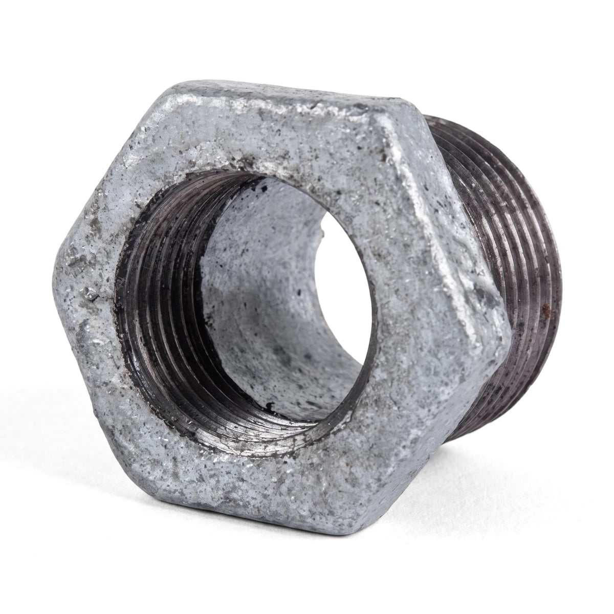 A single galvanized reducing bush with a hexagonal body and threaded ends is displayed against a white background, angled