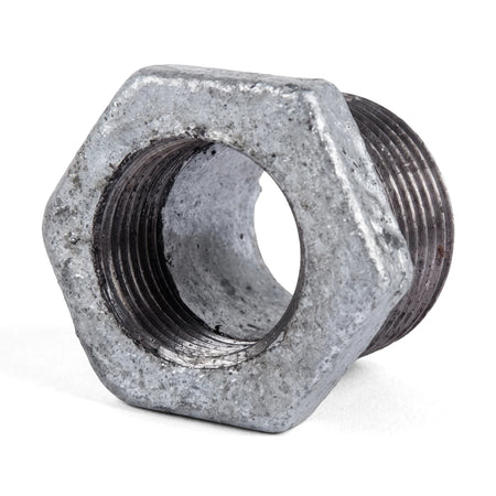 Close-up view of a metal galvanized reducing bush, showing its hexagonal body and threaded interior and exterior for