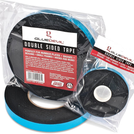 Double-sided black GlueDevil mounting tape rolls in clear plastic packaging, shown from a slight overhead angle.