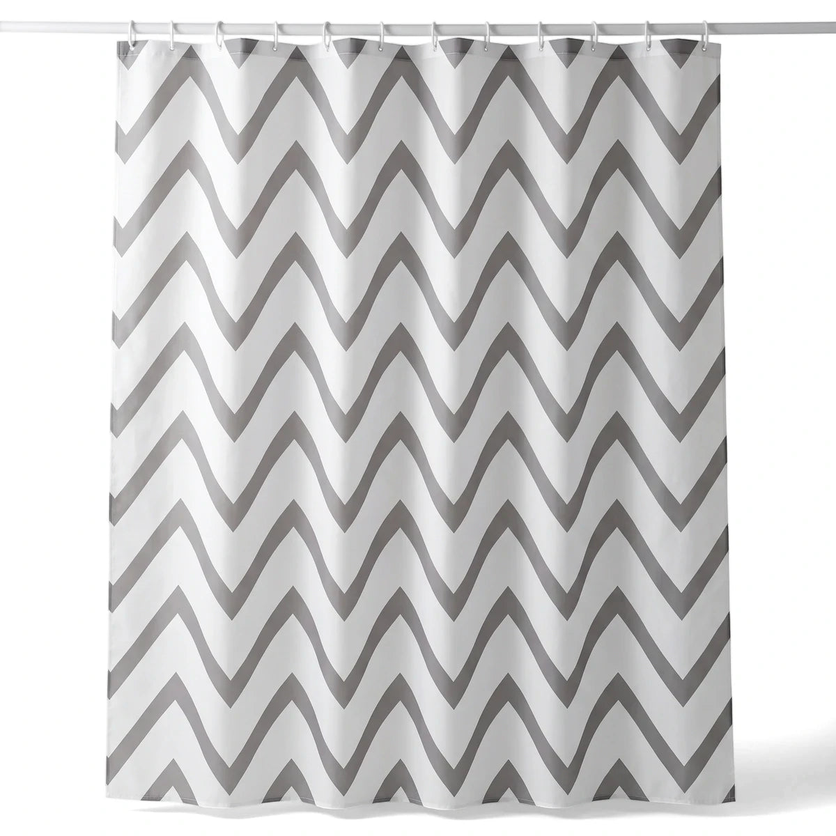 Grey and white chevron patterned fabric shower curtain hanging on a rod, showcasing its flowing wave design.