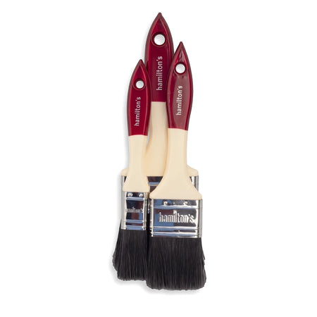 Three Hamilton's utility paint brushes of varying sizes with red handles and dark bristles, displayed upright.