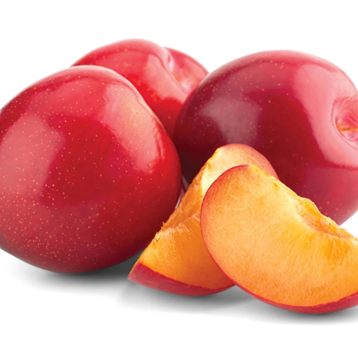 Fresh Harry Pickstone red plums, some whole and some sliced open to reveal their orange-yellow flesh, arranged on a white