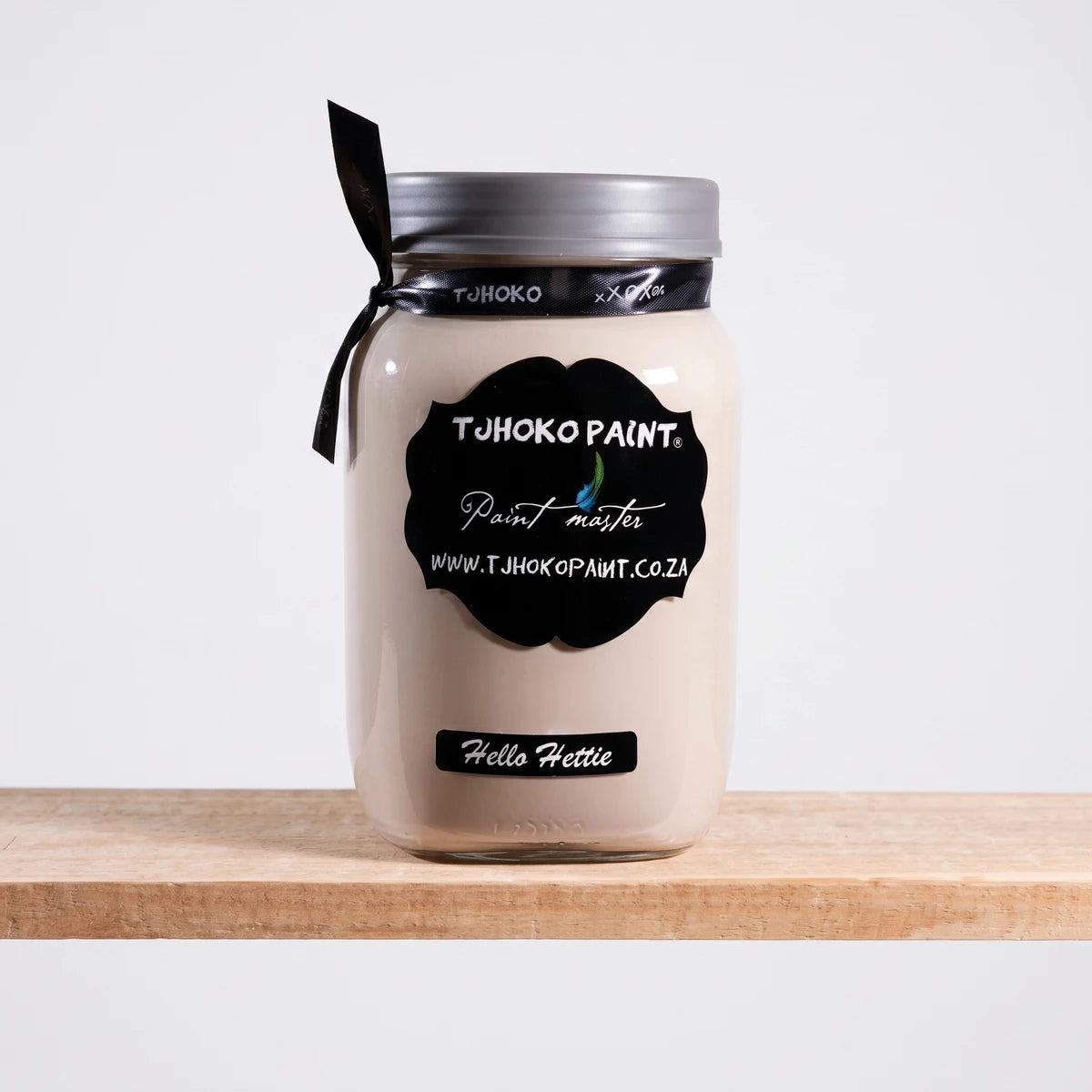 Hello Hettie 25ml Chalk Paint in a glass jar with black labels and a black ribbon, displayed on a wooden surface.