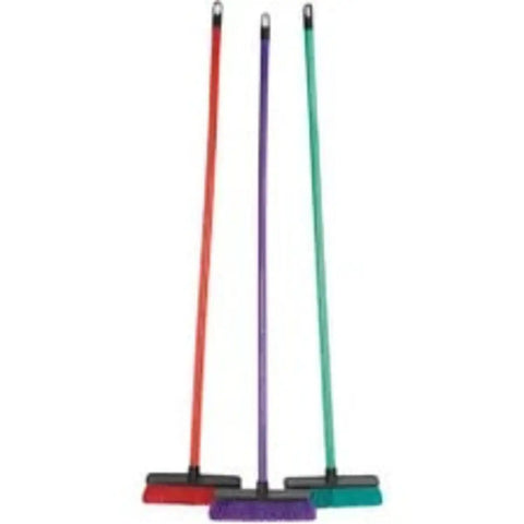 three Addis brooms with red, purple and green handles and matching heads standing upright