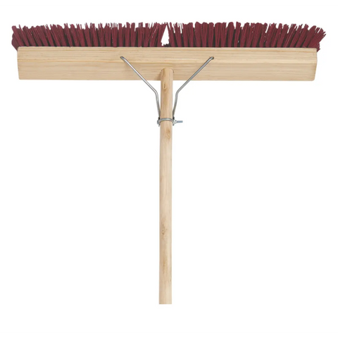 addis heavy duty broom with a wide wooden head and maroon stiff bristles on a wooden handle