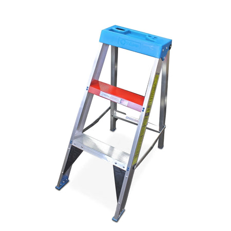 Industrial aluminum step ladder with a blue utility tray and red top step, viewed from an angled perspective on a white