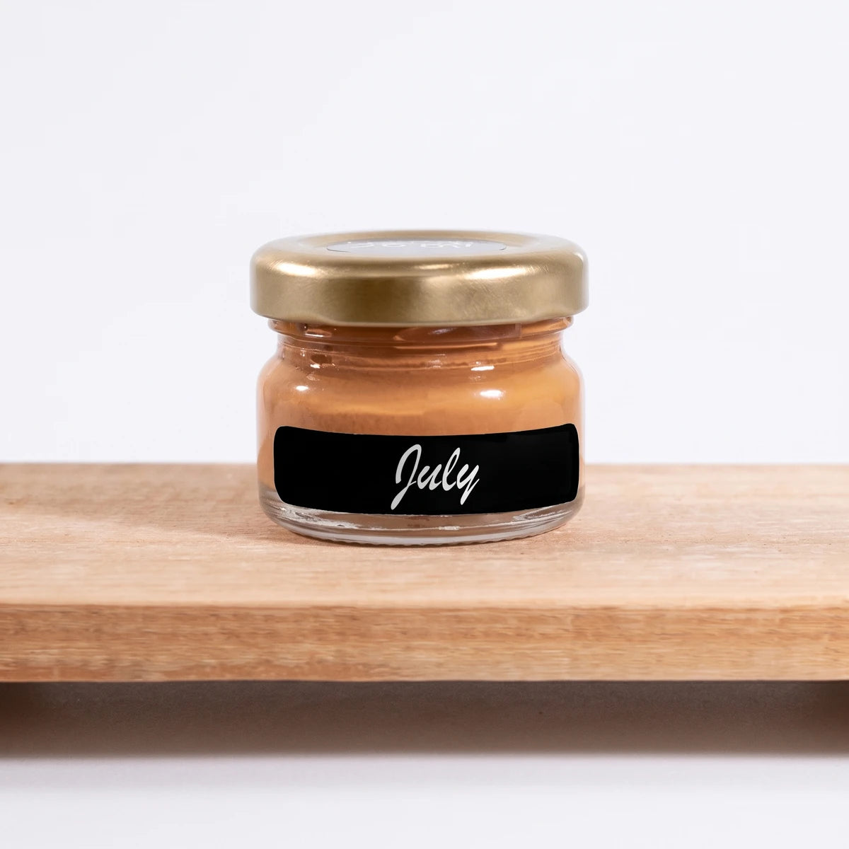 July 25ml Chalk Paint in a small glass jar with a gold lid, labeled 'July', on a light wooden shelf.