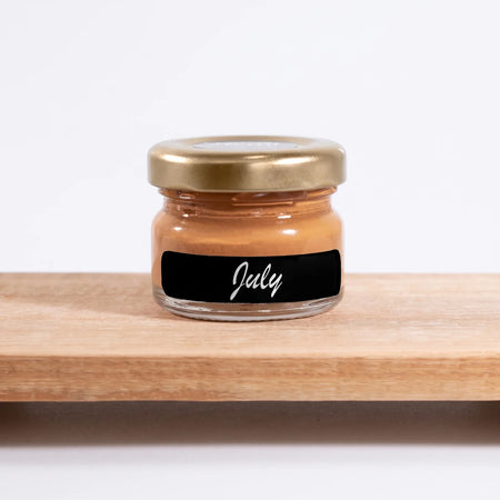 July 25ml Chalk Paint in a small glass jar with a gold lid, labeled 'July', on a light wooden shelf.