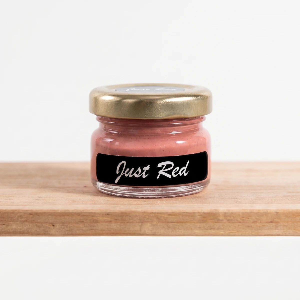 Small jar of Just Red 25ml chalk paint with a gold lid and black label, displayed on a wooden shelf.