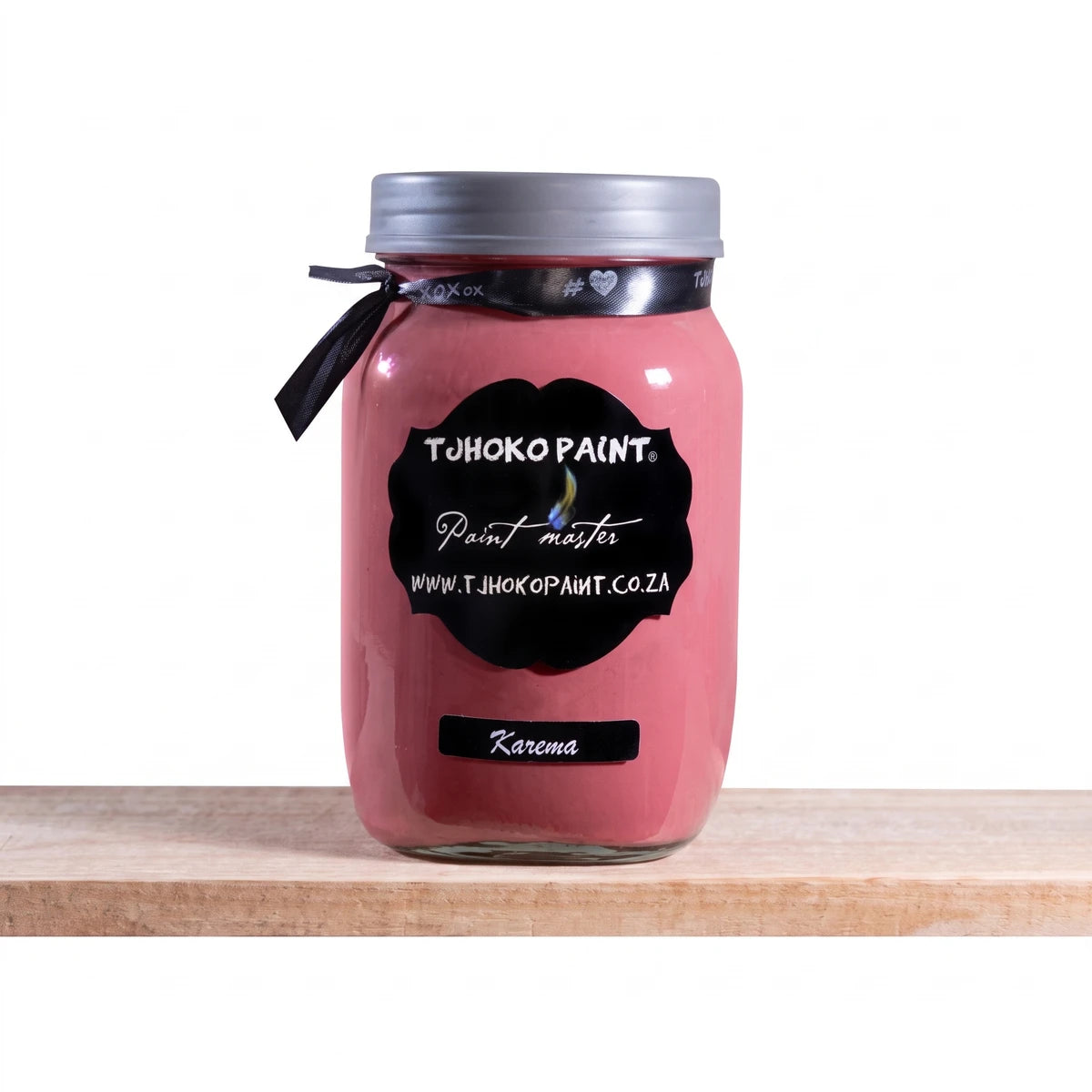 Karema 1L Chalk Paint in a pinkish-red glass jar, featuring a black label and silver lid, displayed on a wooden shelf.