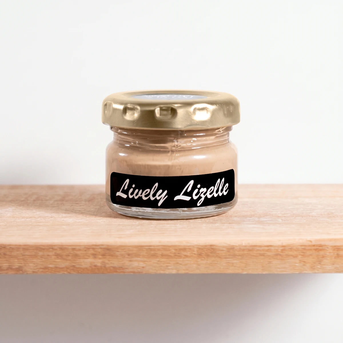 Small glass jar of Lively Lizelle 25ml chalk paint with a gold lid and black label, showcasing the light brown color.