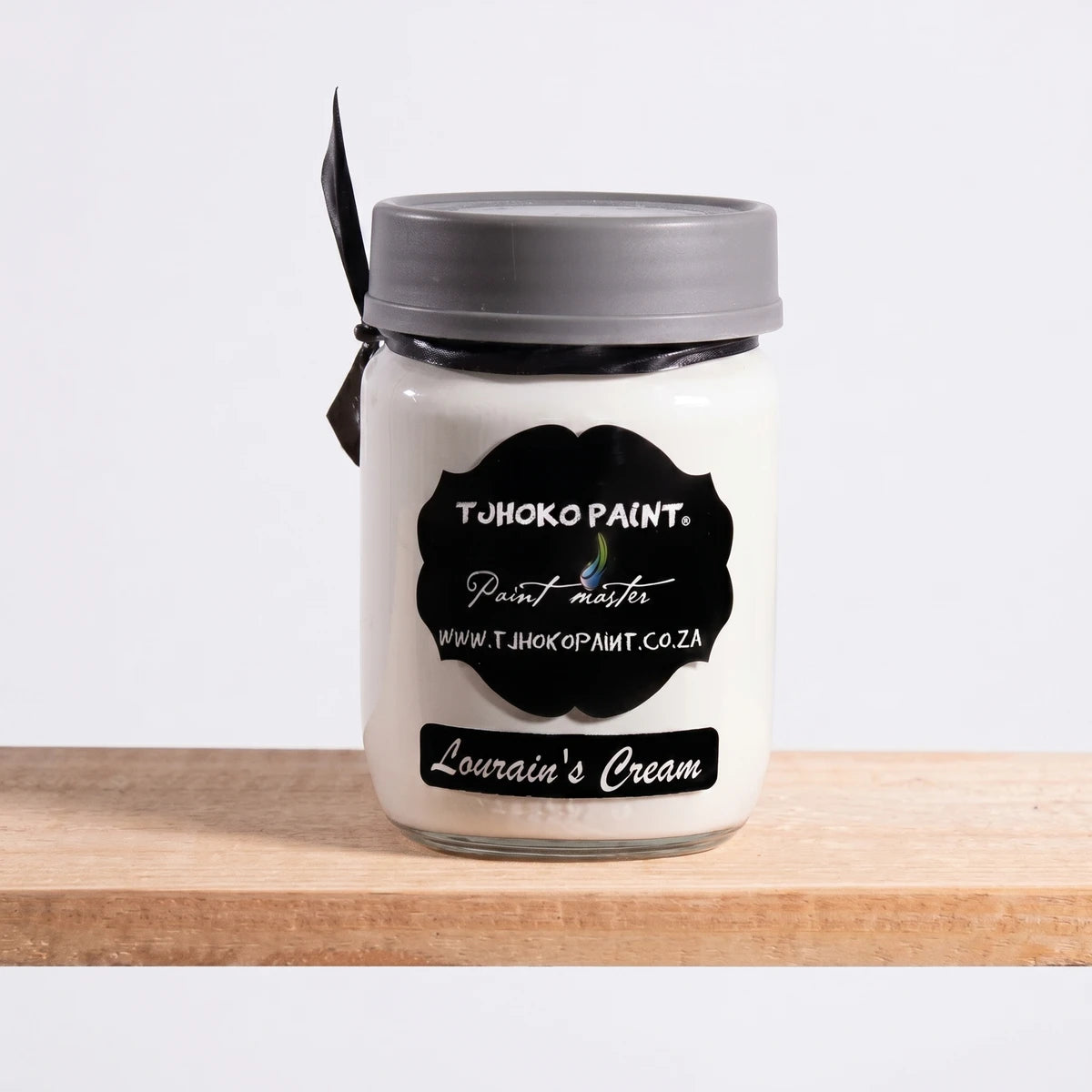 Lourain's Cream 250ml chalk paint in a white glass jar with a grey lid and black label on a wooden shelf.