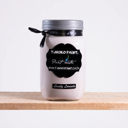 A white jar of Tjhoho Paint Lovely Lorinda 1L chalk paint with a silver lid and black label, sitting on a light wooden shelf.