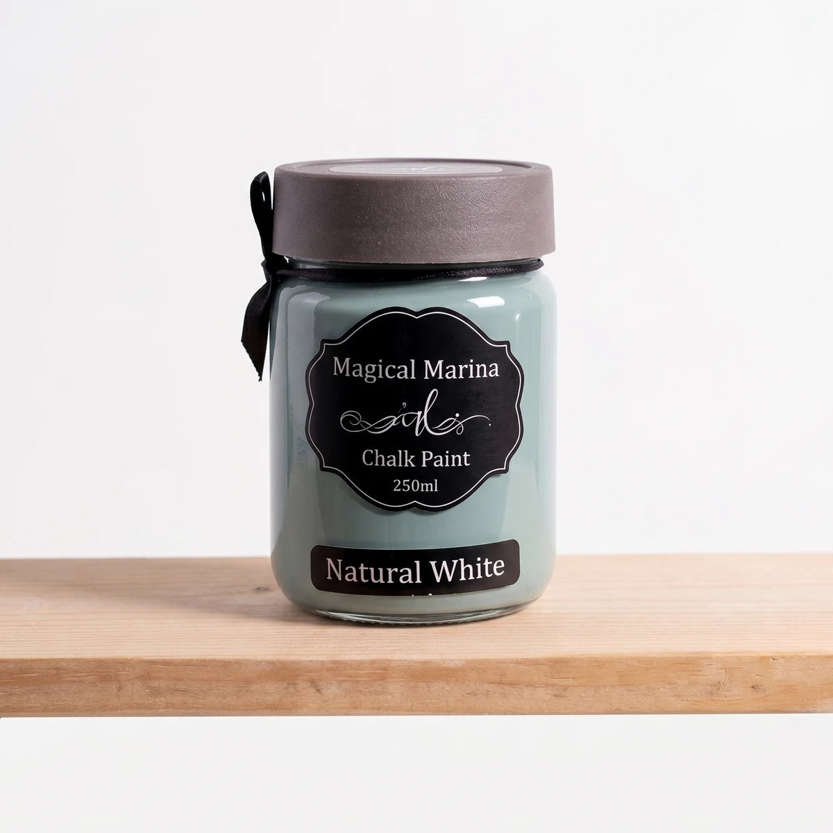 Magical Marina 250ml Chalk Paint in a teal-green glass jar with a dark grey lid and black label, standing on a wooden