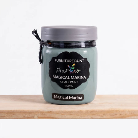 A 500ml jar of Magical Marina chalk paint in a muted teal-green shade, with a black label, on a wooden surface.
