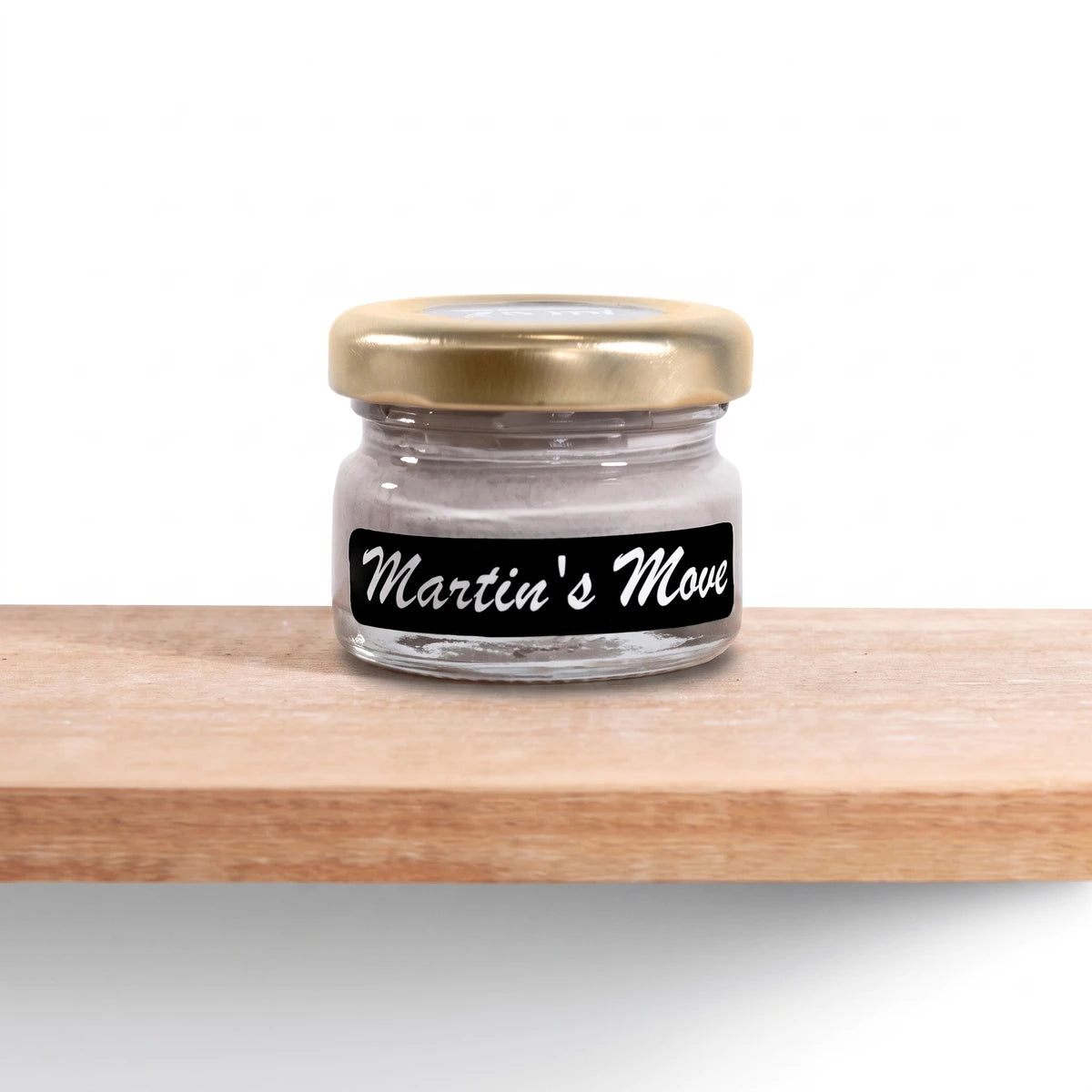 Martin's Move 25ml chalk paint jar with a gold lid and black label, filled with light grey paint, displayed on a wooden